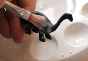 make glittered dinosaur ornaments paint with glue